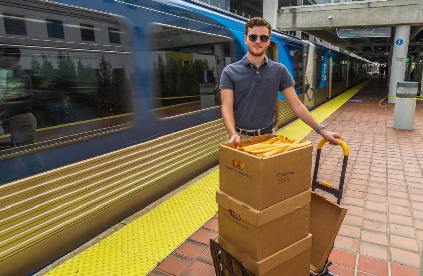 Transit advocate Kevin Amézaga poses at the Overtown Metrorail station platform with boxes full of Metrorail's public records