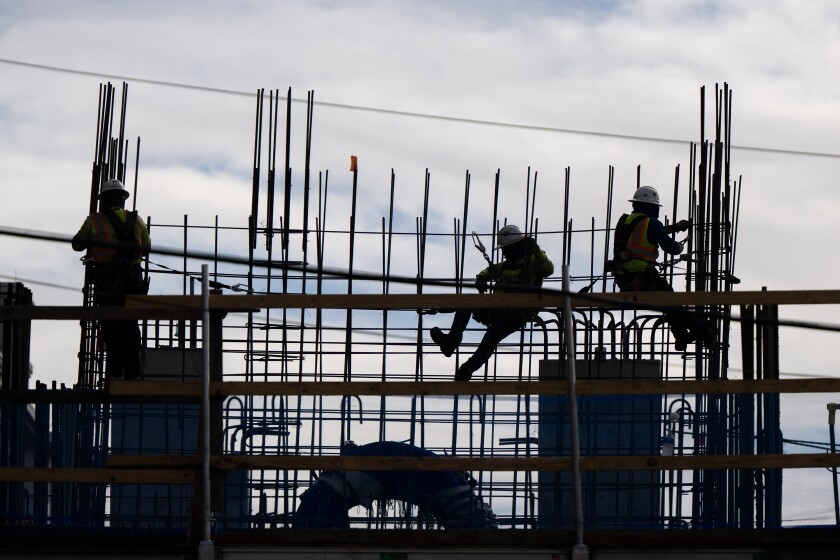 Construction workers work on a building