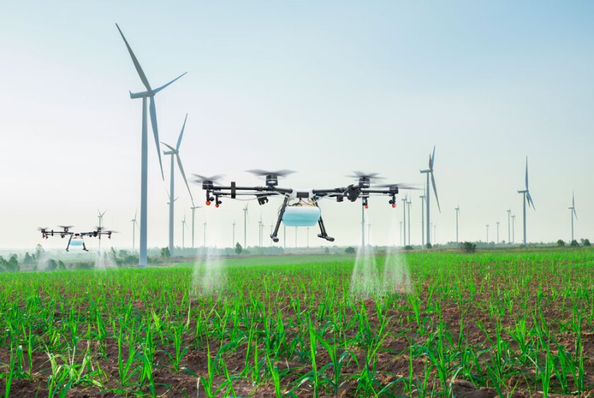drones+flying+over+a+field+watering+crops