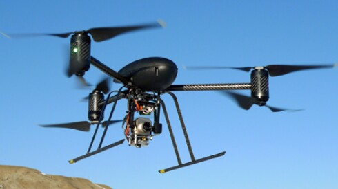A drone flying against a blue sky.