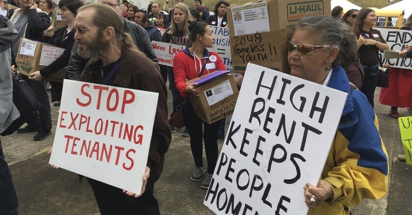 Protesters hold signs.