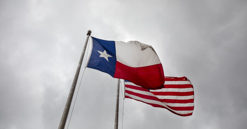The Texas and U.S. flags wave outside the John H. Reagan State Office Building