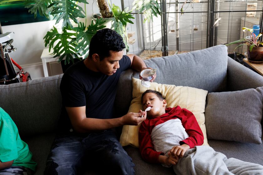 a man feeds his 7-year-old son who has disabilities