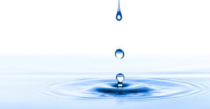Closeup of drops of water falling into water.