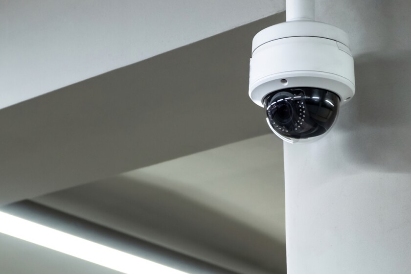 A surveillance camera mounted to a concrete pole.
