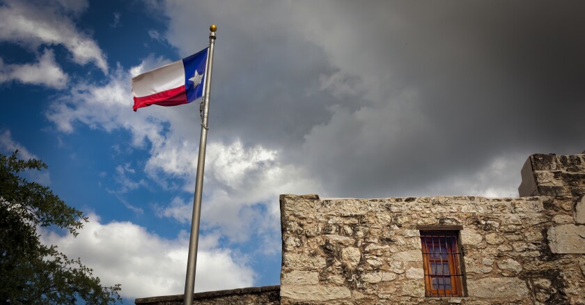 The Texas flag on a flagpole next to the Alamo.