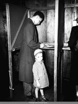 Black-and-white photograph of an Atlanta constituent placing his vote for the special Congressional election in 1946.