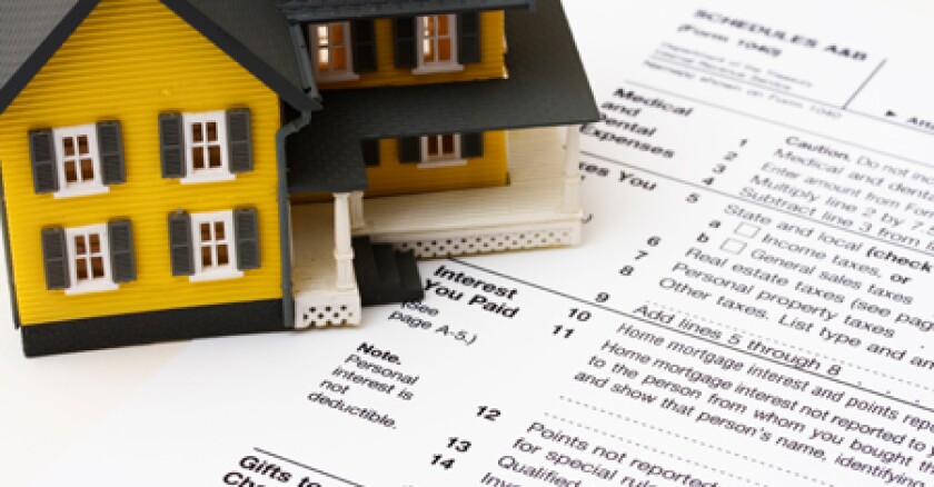 A document with a miniature yellow house near it.