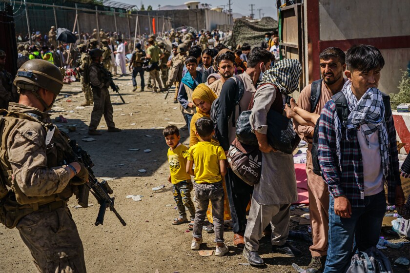U.S. soldiers watching over Afghans waiting to be processed for evacuation flights out of Kabul, Afghanistan.