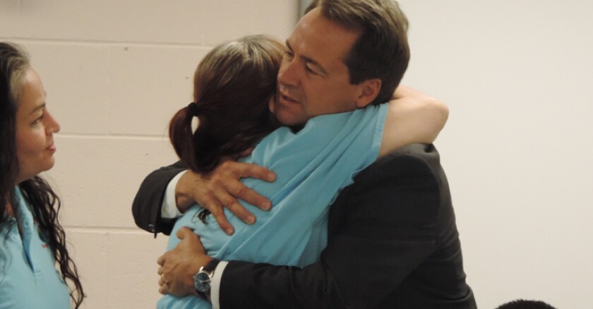 An inmate hugging Montana Gov. Steve Bullock.
