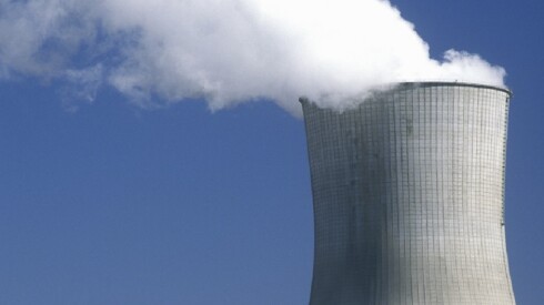 Exhaust coming out of the top of a nuclear reactor against a blue sky.