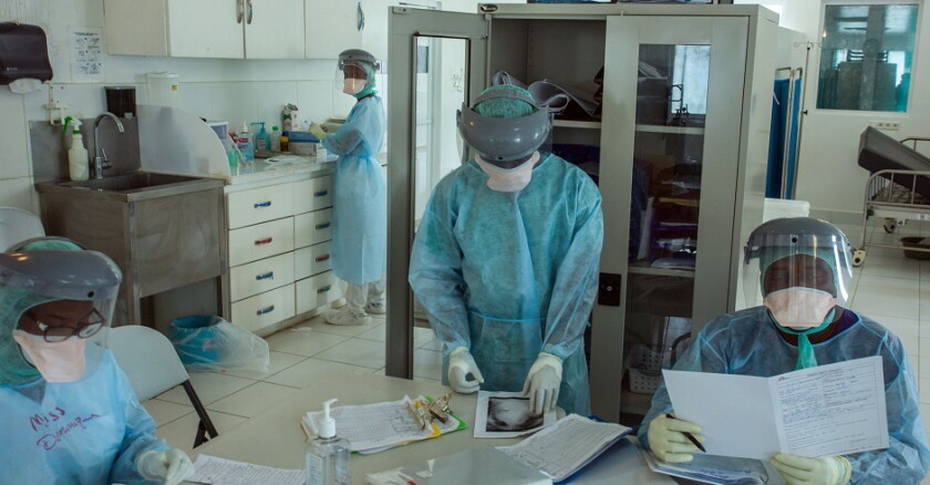 Three health-care workers sitting around a table.
