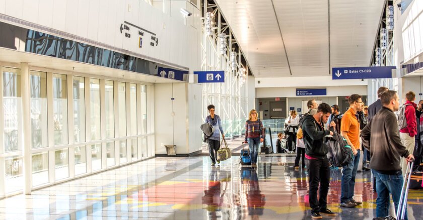 People waiting in line inside an airport.