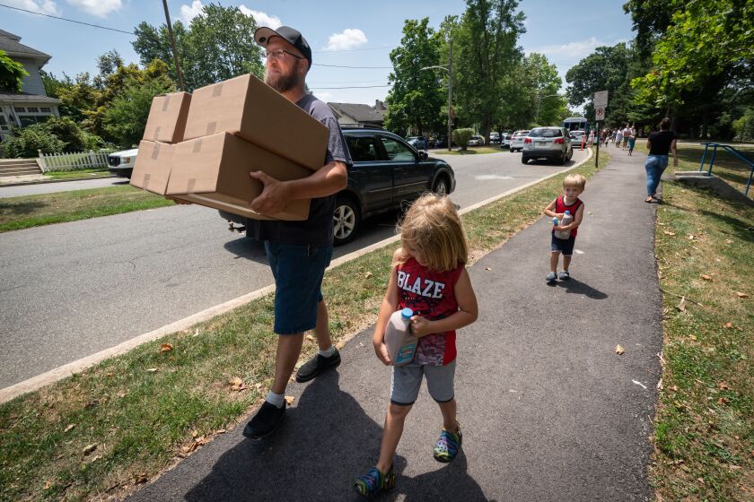 A father and his children collect donated food from a park in Pennsylvania.